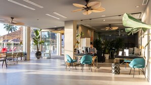 Amplio espacio interior con una recepción, varias sillas y una persona trabajando en el mostrador.