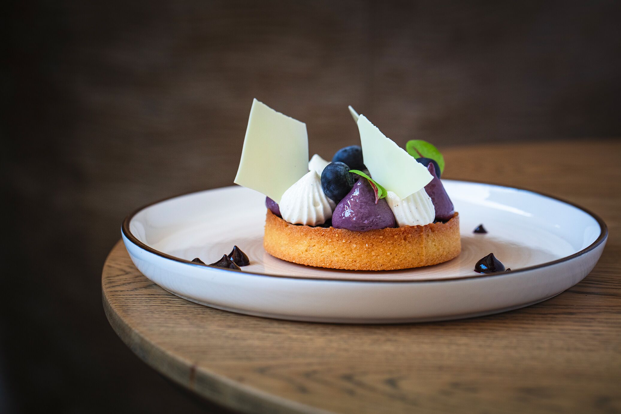 Un postre sobre un plato blanco con virutas de chocolate.