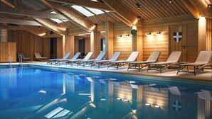 Una piscina interior de madera con sillones de descanso y techo de madera.