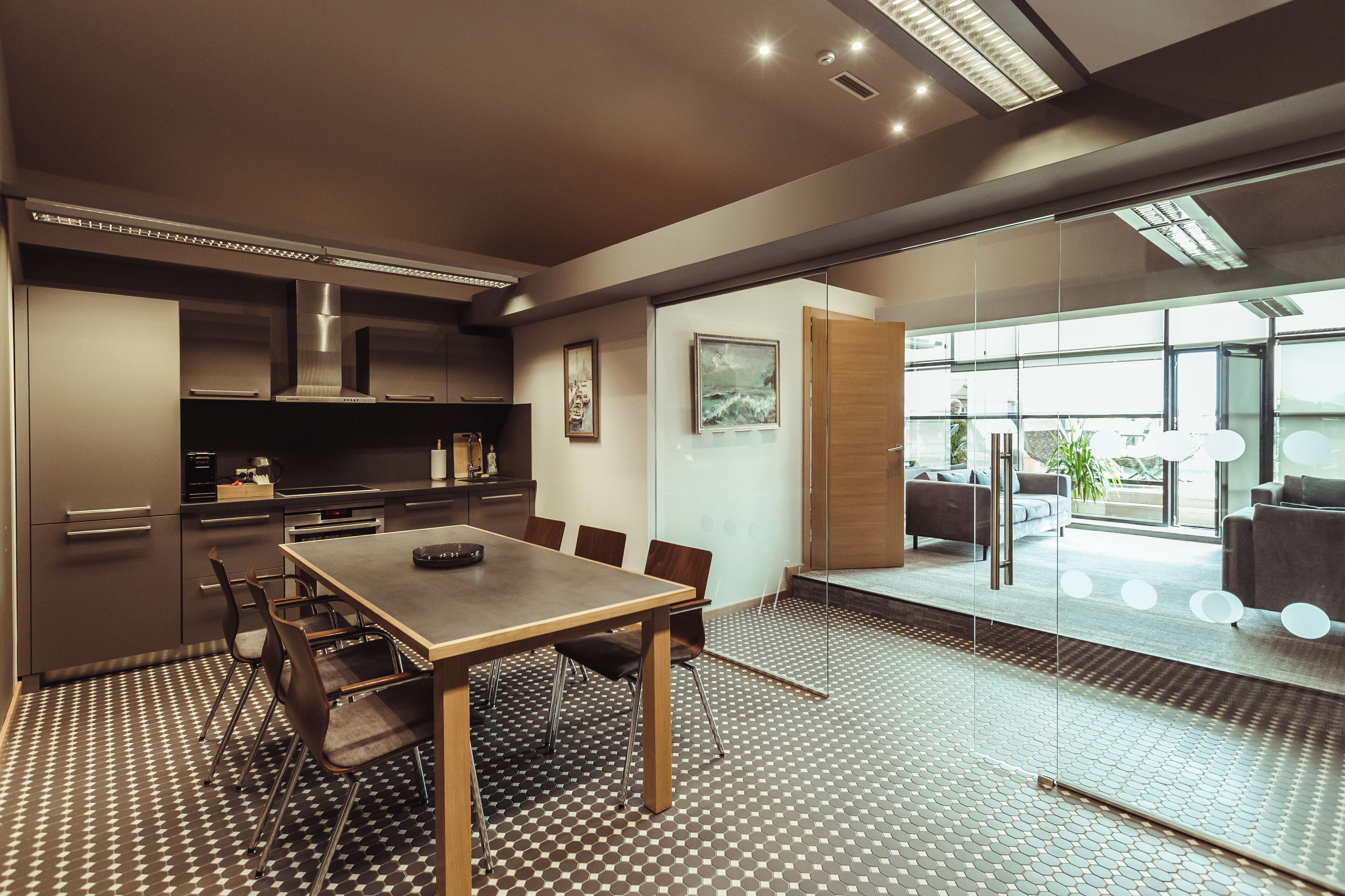 Una cocina moderna con comedor, que incluye una mesa grande, sillas y piso estampado.