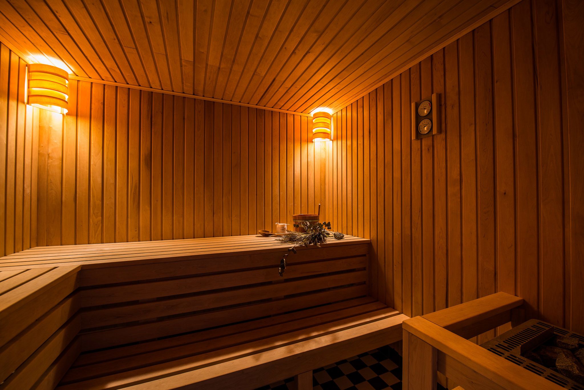 A wooden sauna with benches and a bench with a footrest.