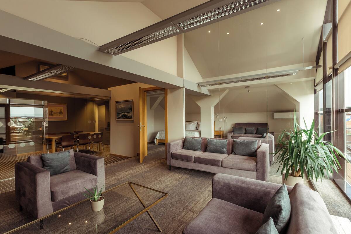 A spacious living area with a large sofa set, a coffee table, and a potted plant.