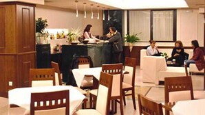 Una hall d'albergo con reception, area salotto e un bar.