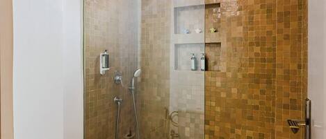 A modern bathroom with a glass-enclosed shower, a toilet, and a sink.