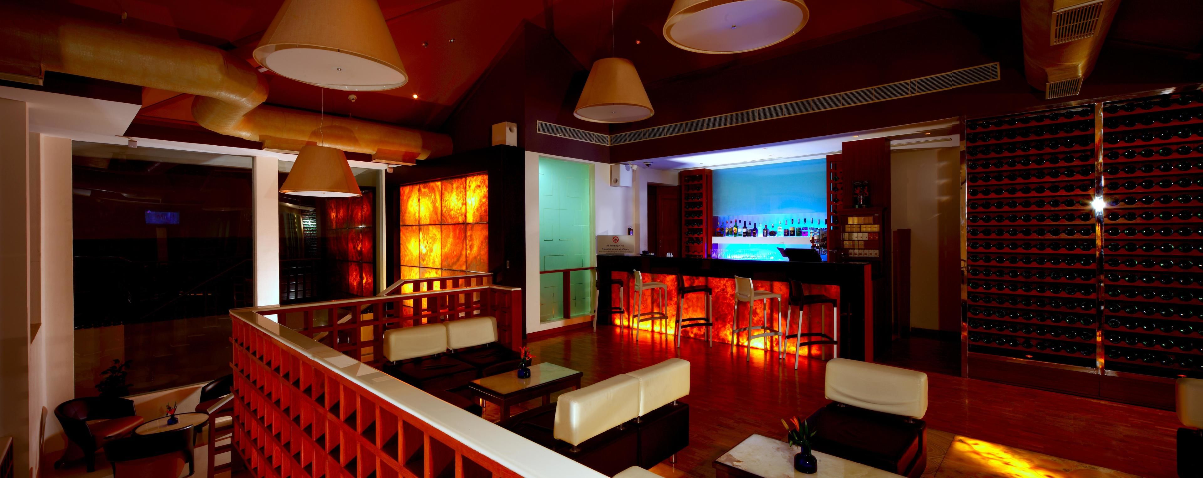A bar area with a wine rack, seating, and a counter.