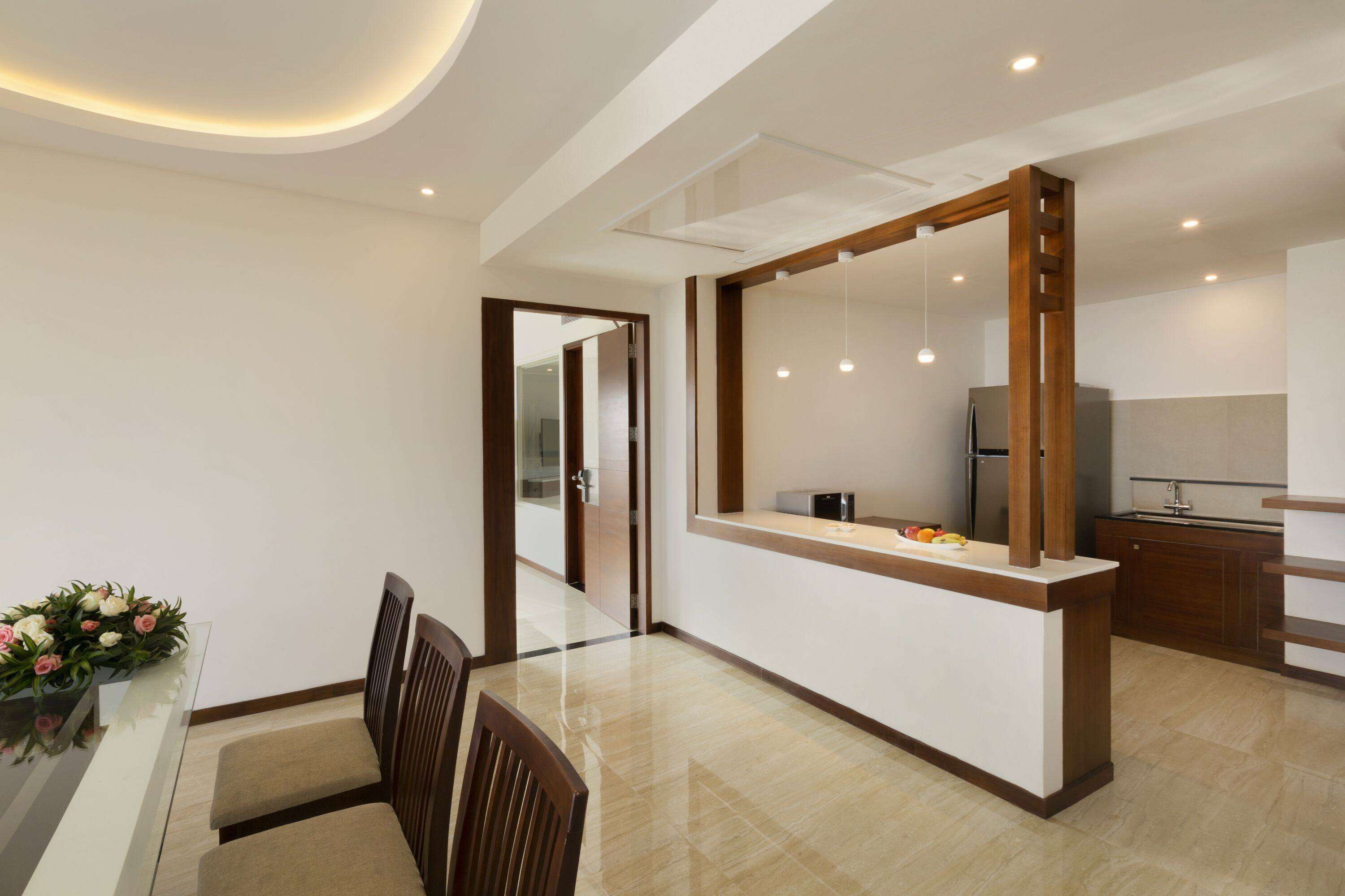 A modern kitchen with a central island, wooden cabinets, and a built-in microwave.