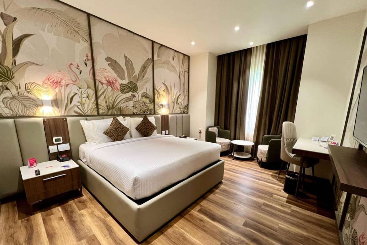 Quarto de hotel moderno com uma cama grande, uma mesa, uma cadeira e uma pequena mesa.