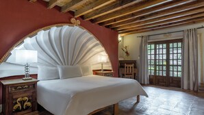 A bedroom with a large bed, wooden headboard, and a view of the outdoors through a window. - Hotel Atotonilco El Viejo (San Miguel de Allende)