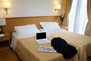 A hotel room with a bed, a laptop, a newspaper, and a jacket on the bed. - Hotel Marco Polo (Mestre)