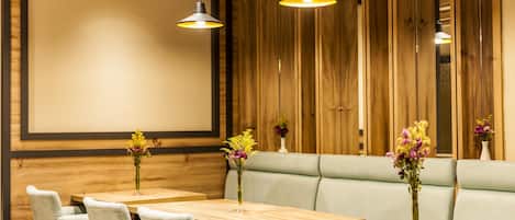 L’intérieur d’un restaurant est agrémenté de murs lambrissés, de sièges rembourrés et de luminaires suspendus.