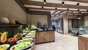 A modern kitchen with a long counter displaying various food items and a coffee station. - Hotel Kupeli (Istanbul)