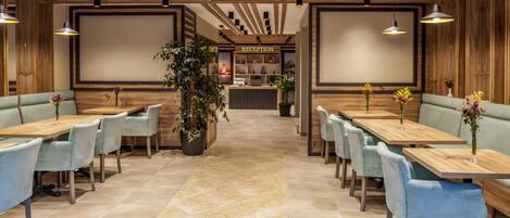 A reception area with a reception desk, seating arrangements, and a plant.