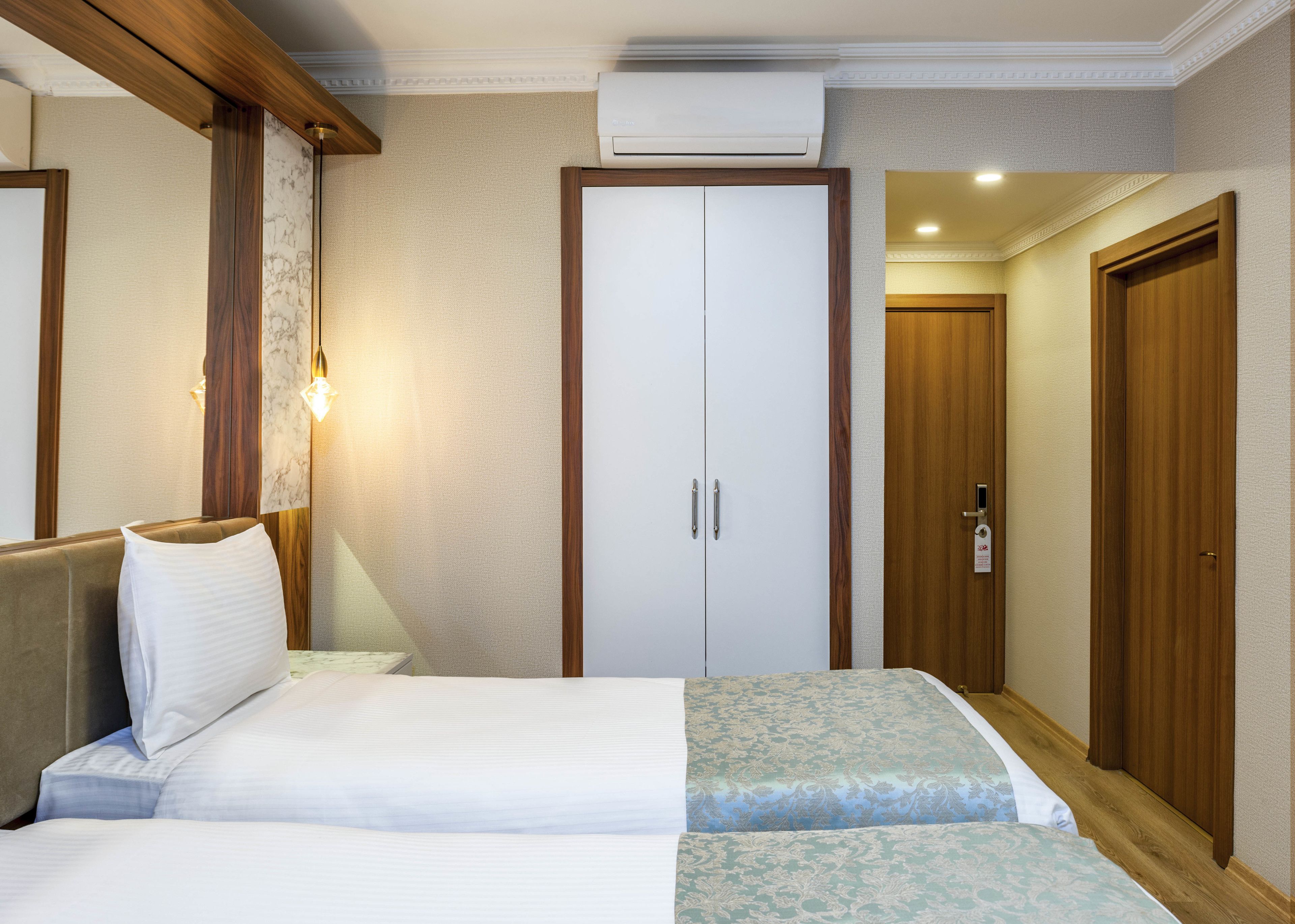 Una habitación de hotel con una cama, un armario y una puerta.