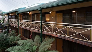 A hotel with a covered walkway, brick walls, and large windows. - Mayfair Plaza Motel (Sandy Bay)