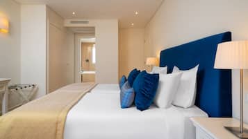 Una habitación de hotel moderna con una cama grande, una mesita de noche y una lámpara.