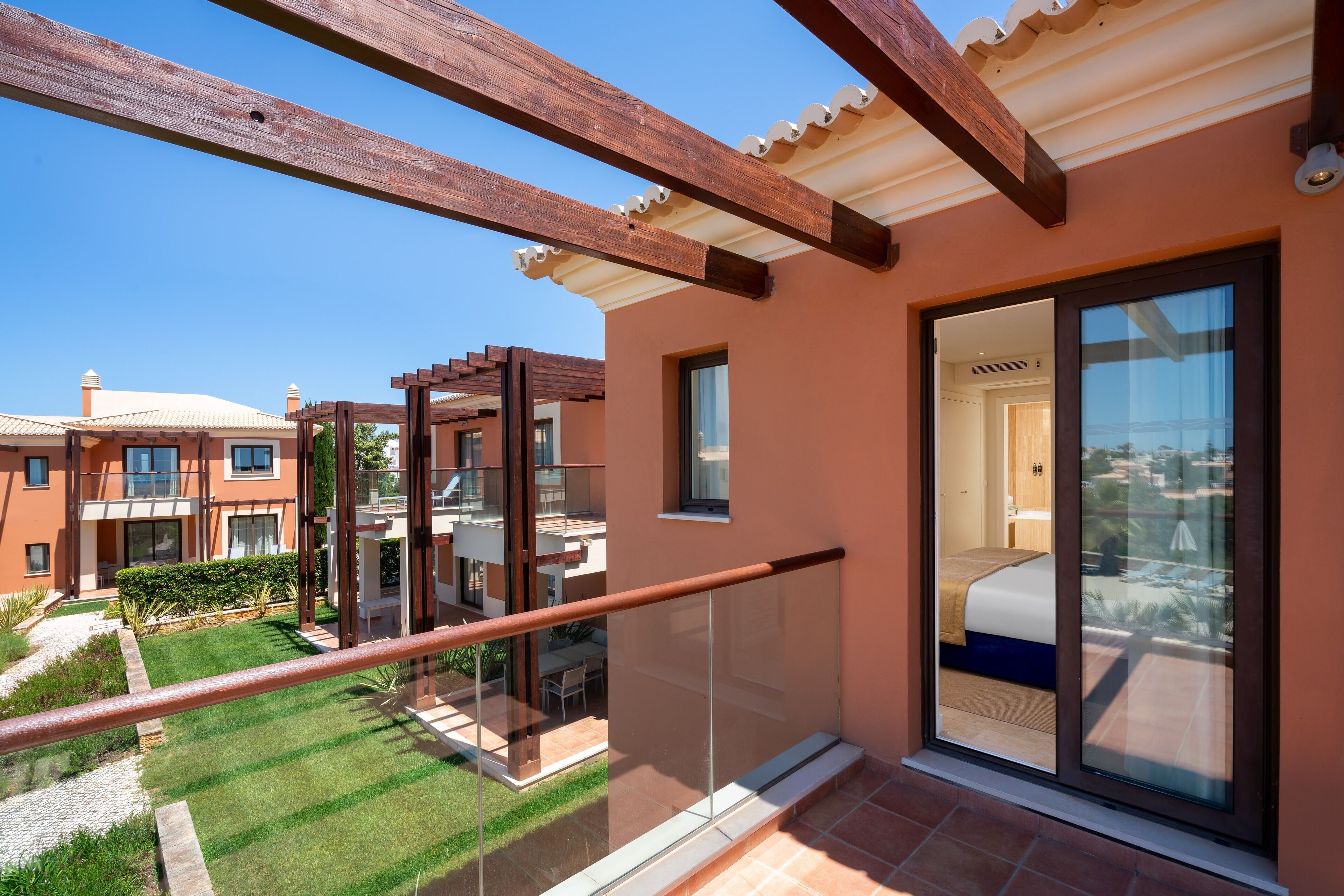 Un apartamento moderno con balcón, ventanas amplias y vistas a edificios cercanos.