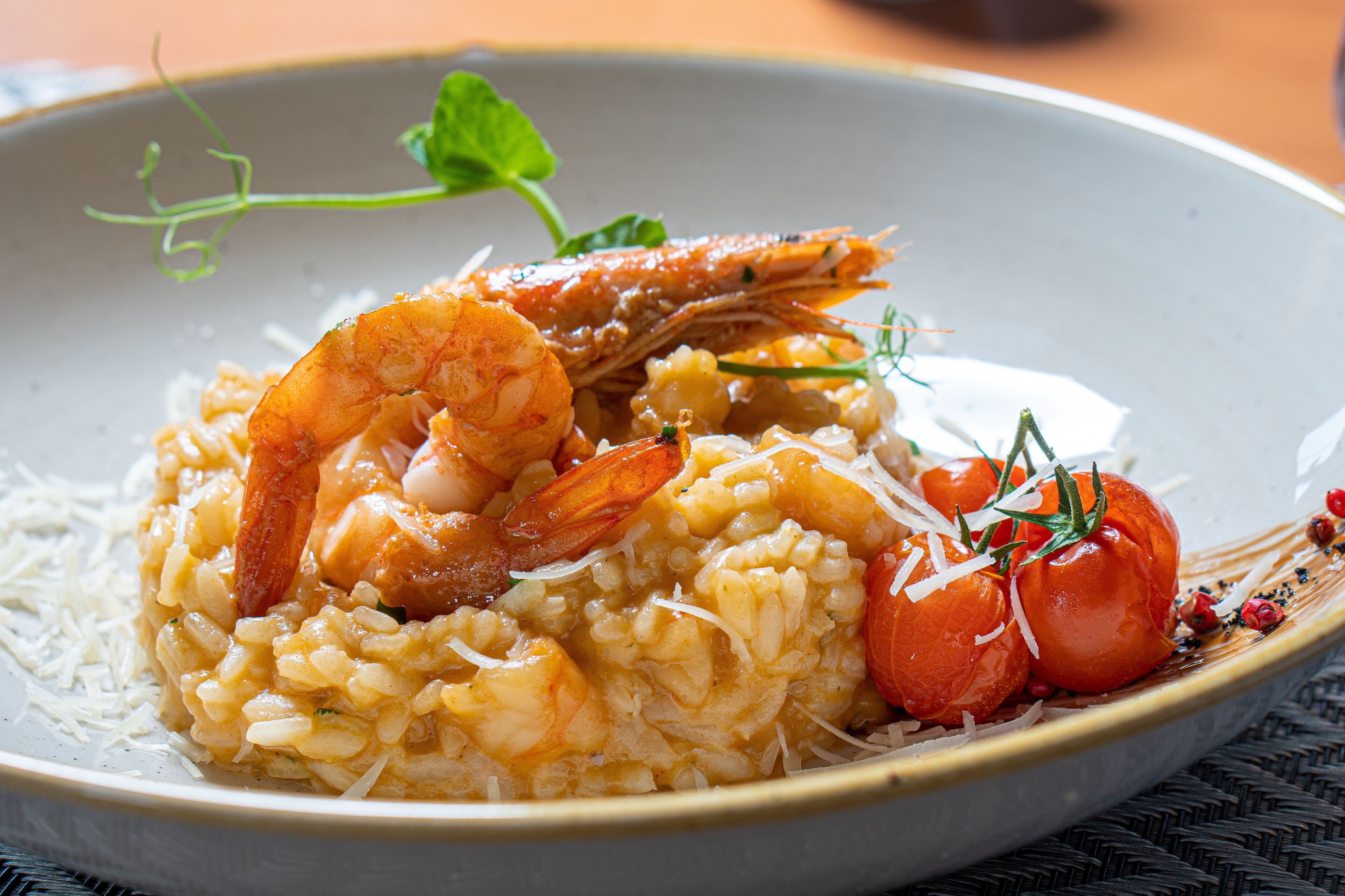 Un plato de risotto de mariscos con camarones y tomates.