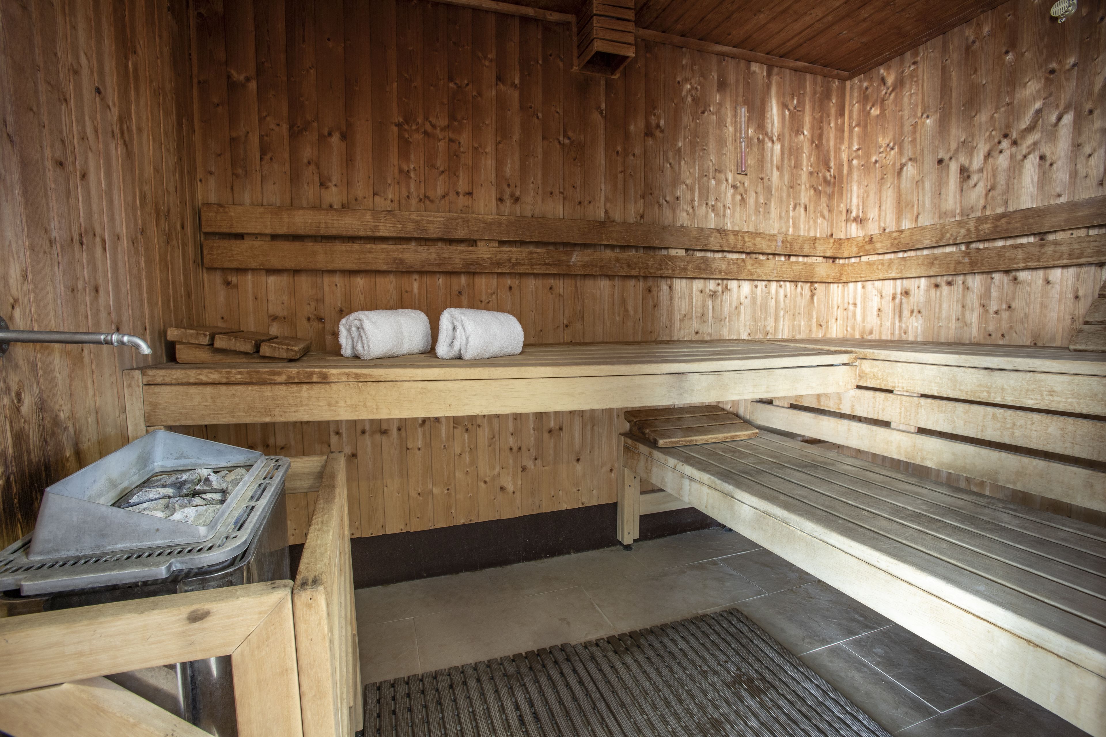Una sauna de madera con bancos y un asiento.