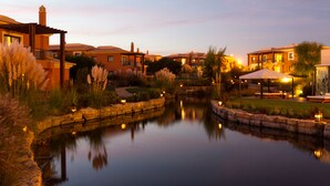 Un entorno tranquilo junto al lago, con un sendero de piedra, un pergolado de madera y una zona de patio bien iluminada.