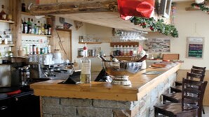 Una cocina con una isla de piedra, armarios de madera y una zona de bar con sillas.