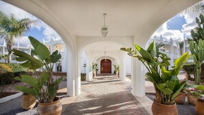 A covered walkway with potted plants and a wooden door at the end. - L'amphitrite Palace Resort & Spa (Skhirat)