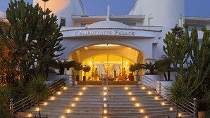 The entrance of L'Amphitrite Palace with a grand staircase leading up to the entrance, surrounded by cacti and palm trees. - L'amphitrite Palace Resort & Spa (Skhirat)