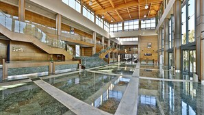 A spacious lobby with a reflective marble floor, a central staircase, and a high ceiling with wooden beams. - L'amphitrite Palace Resort & Spa (Skhirat)