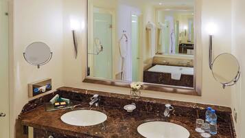 A bathroom with two sinks, a large mirror, and a towel rack.