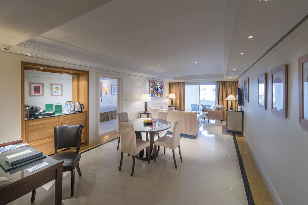 A hotel room with a dining area, a kitchen, and a living area.