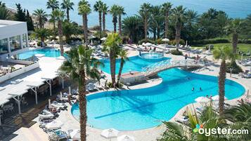 Een binnenzwembad, een buitenzwembad en parasols bij het zwembad