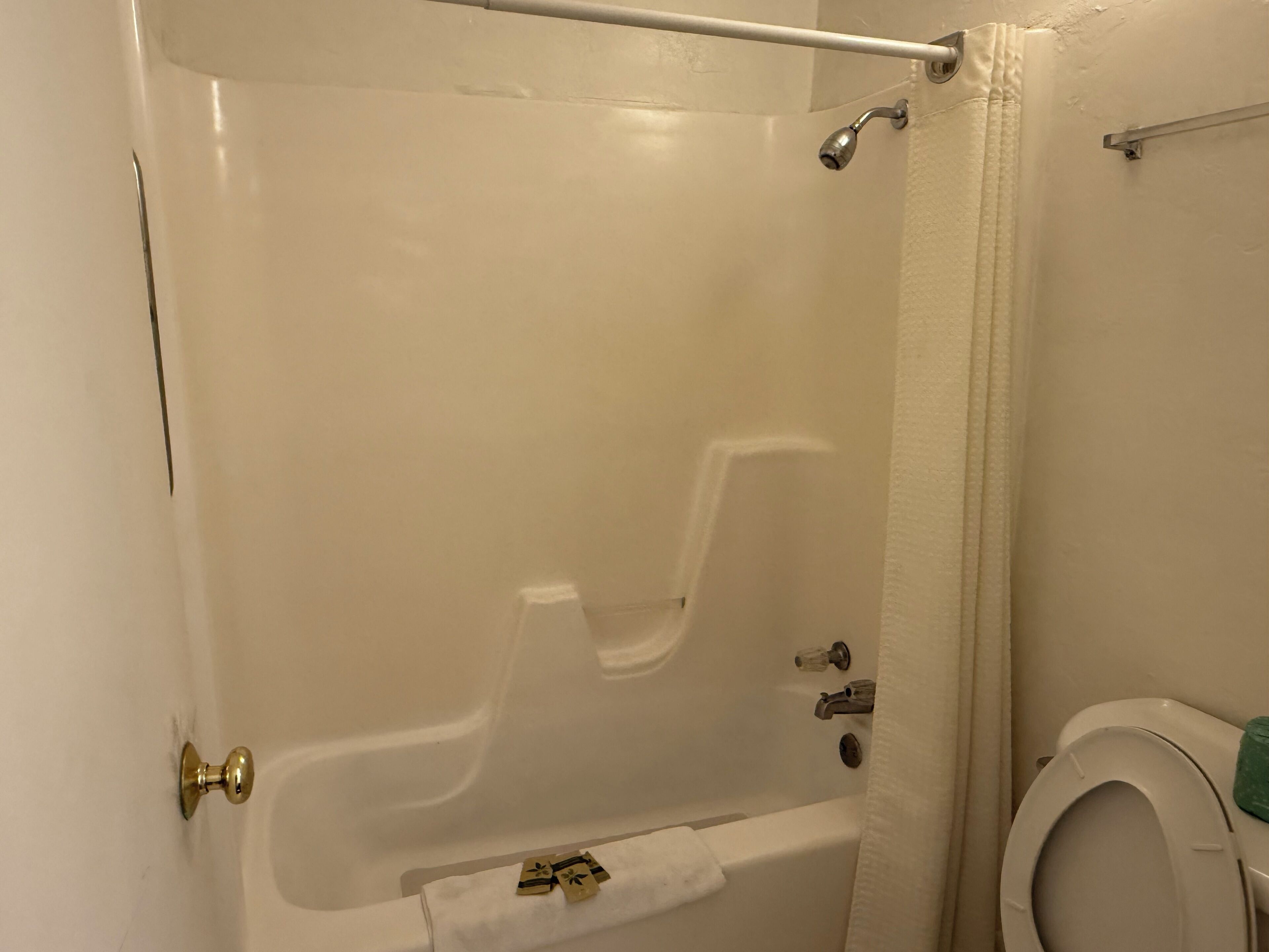 A bathroom with a bathtub, toilet, and a towel rack.
