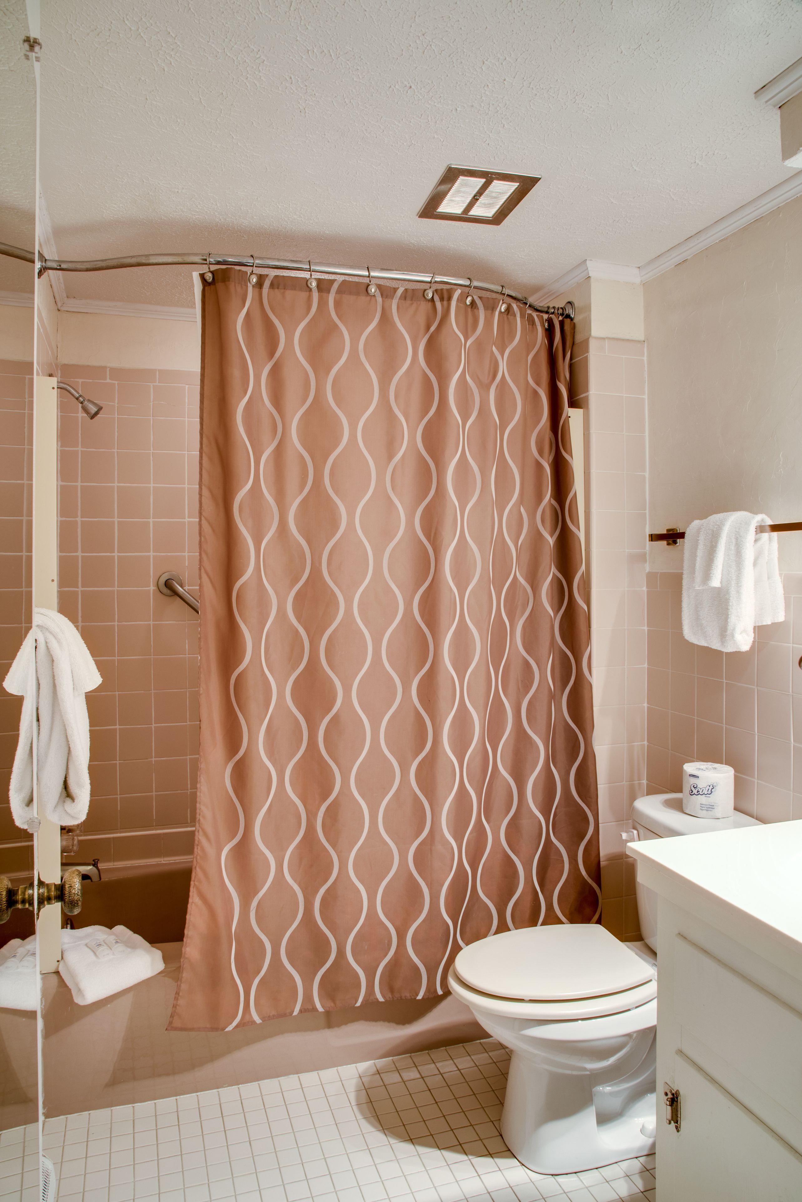 Ein Badezimmer mit Duschvorhang, Toilette und Waschbecken.