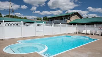 Una piscina al aire libre de temporada, sillones reclinables de piscina