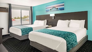 A hotel room with two beds, a large window, and a painting on the wall. - Howard Johnson by Wyndham Gananoque (Gananoque)