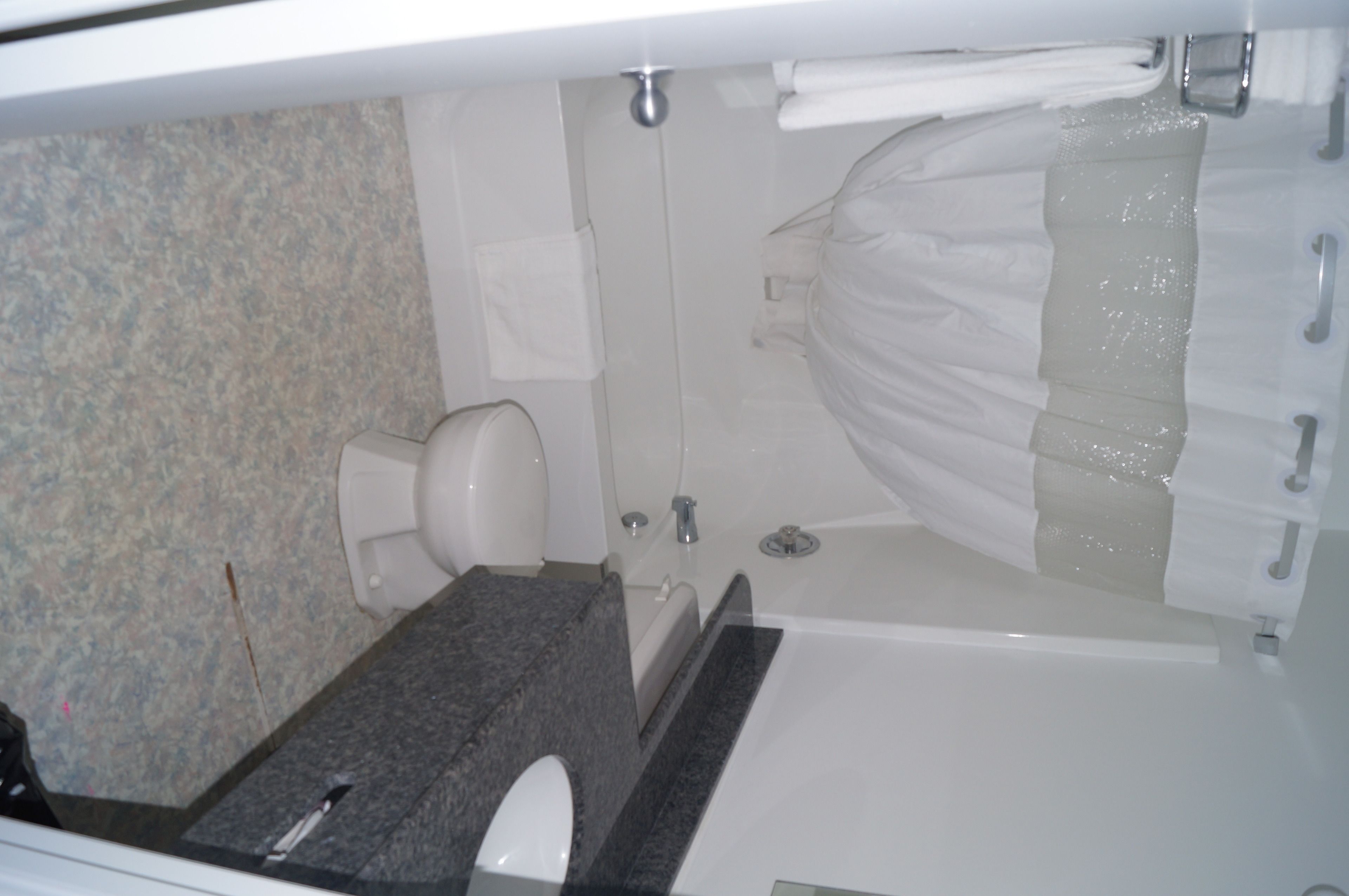 Une salle de bain comprenant des toilettes, un lavabo et un espace douche.