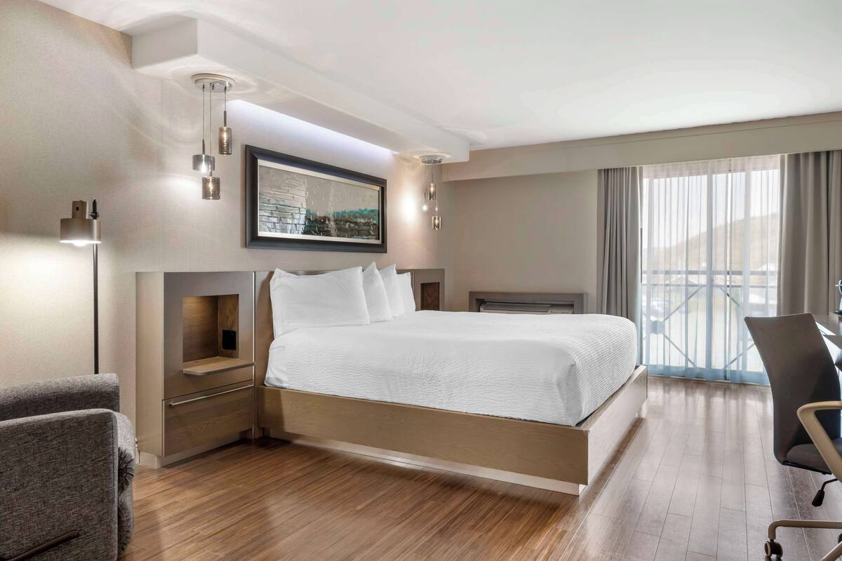 Une chambre d’hôtel moderne, dotée d’un grand lit, d’un bureau et d’une chaise.