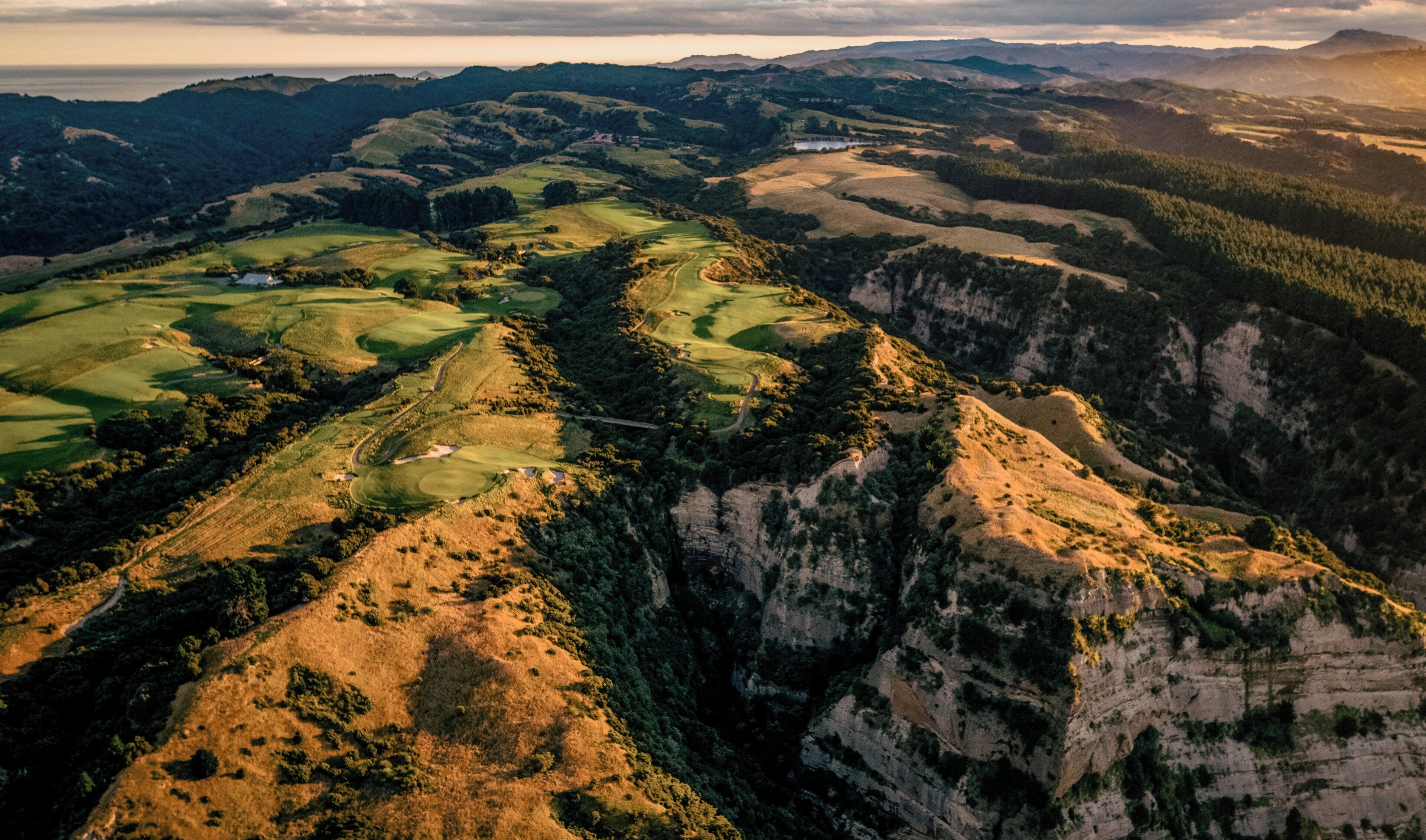 A panoramic view of a mountainous landscape with a golf course.