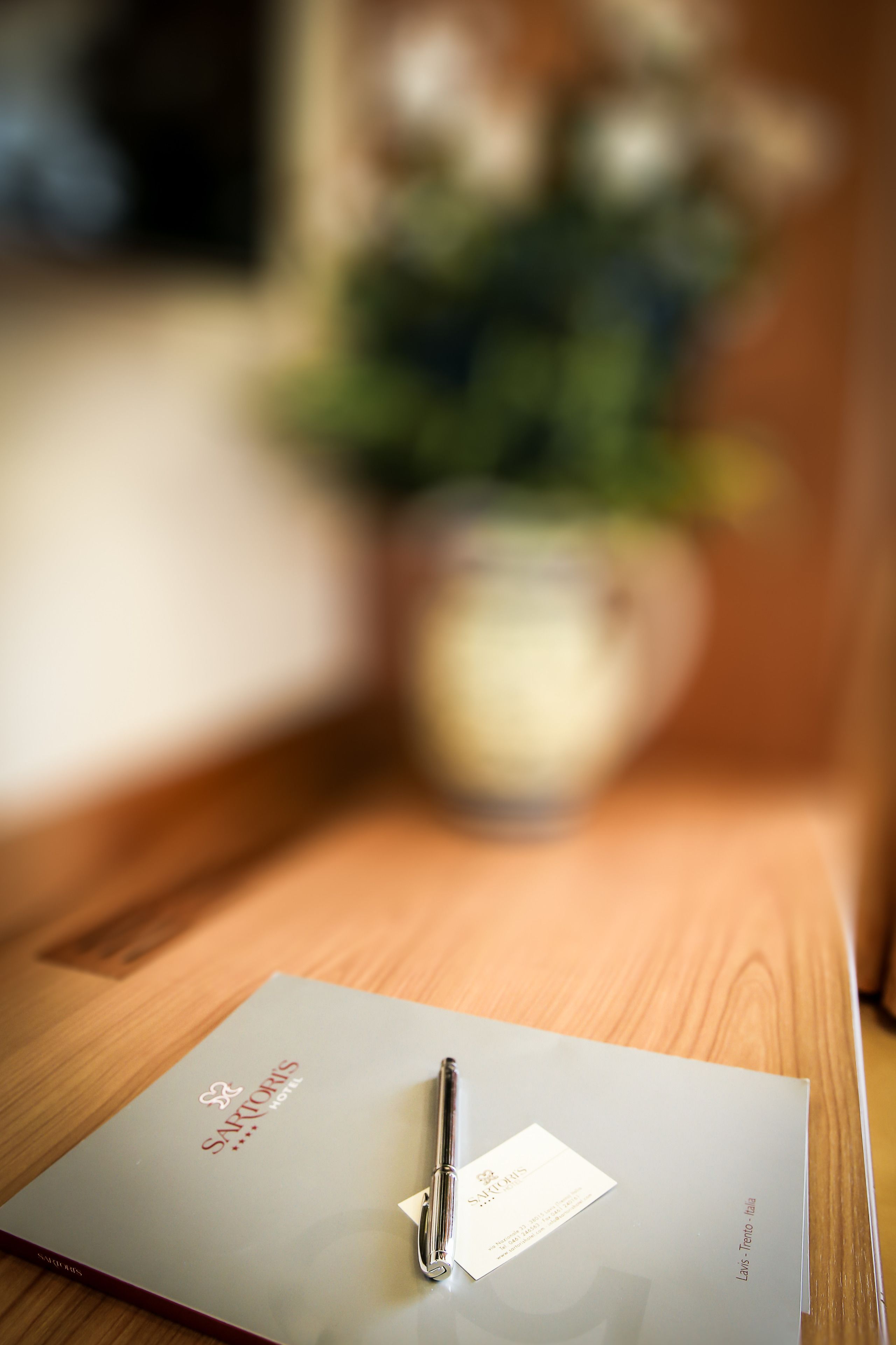 Un folleto de hotel sobre una mesa de madera, con un fondo desenfocado.