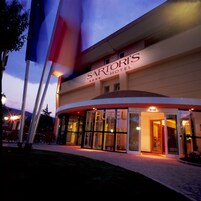 Entrada de un hotel con un letrero que dice "SARTORI'S HOTEL" y fachada de vidrio.