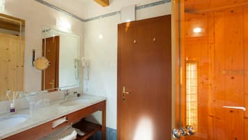 Une salle de bain avec deux lavabos, un miroir et une porte en bois.