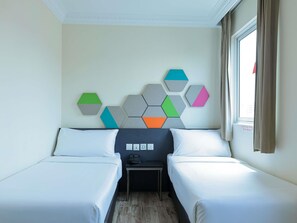 A hotel room with two beds, a small table, and a wall-mounted geometric art piece. - ibis budget Singapore Jasmine (Singapore)