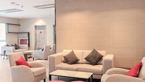 A modern living room with a sofa set, ottomans, and a coffee table.