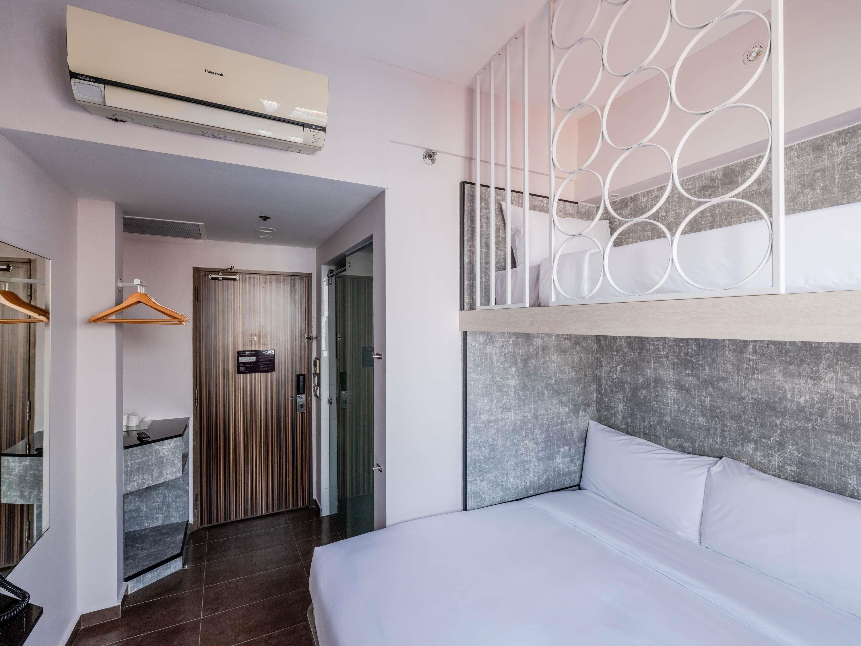 Una habitación de hotel con cama, armario, baño y aire acondicionado.