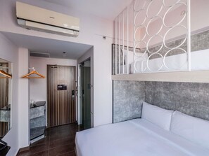 Et hotelværelse med seng, skab, badeværelse og aircondition.