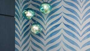 A room with a patterned wallpaper and three hanging spherical light fixtures. - ibis budget Singapore Tulip (Singapore)