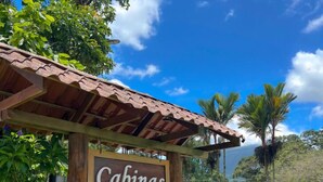 Une enseigne en bois indiquant « Cabinas La Catorata » avec les coordonnées.