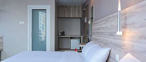 Habitación de hotel moderna con una cama grande, un escritorio, un espejo y vistas a edificios a través de la ventana.