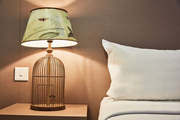 A lamp with a vintage design on a bedside table next to a bed. - ibis budget Singapore Joo Chiat (Singapore)