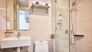 Une salle de bain moderne avec un lavabo, des toilettes et une douche à parois de verre.