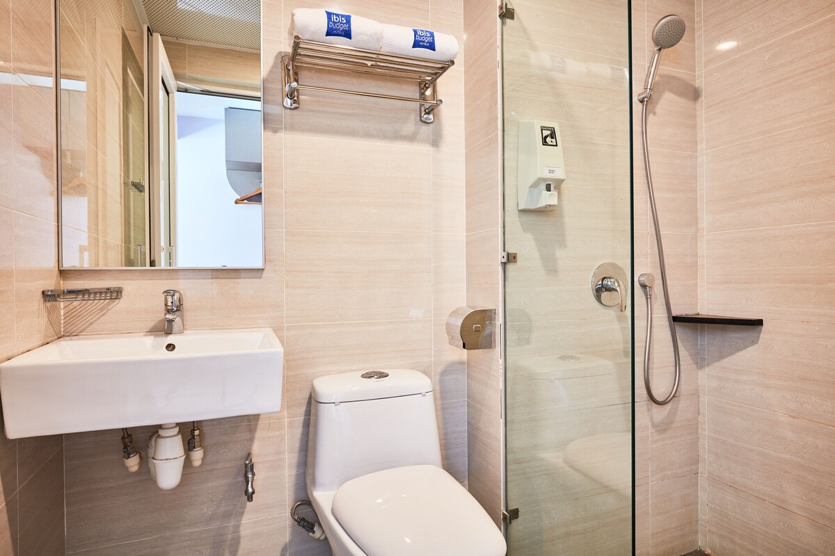 A modern bathroom with a sink, toilet, and glass-enclosed shower.